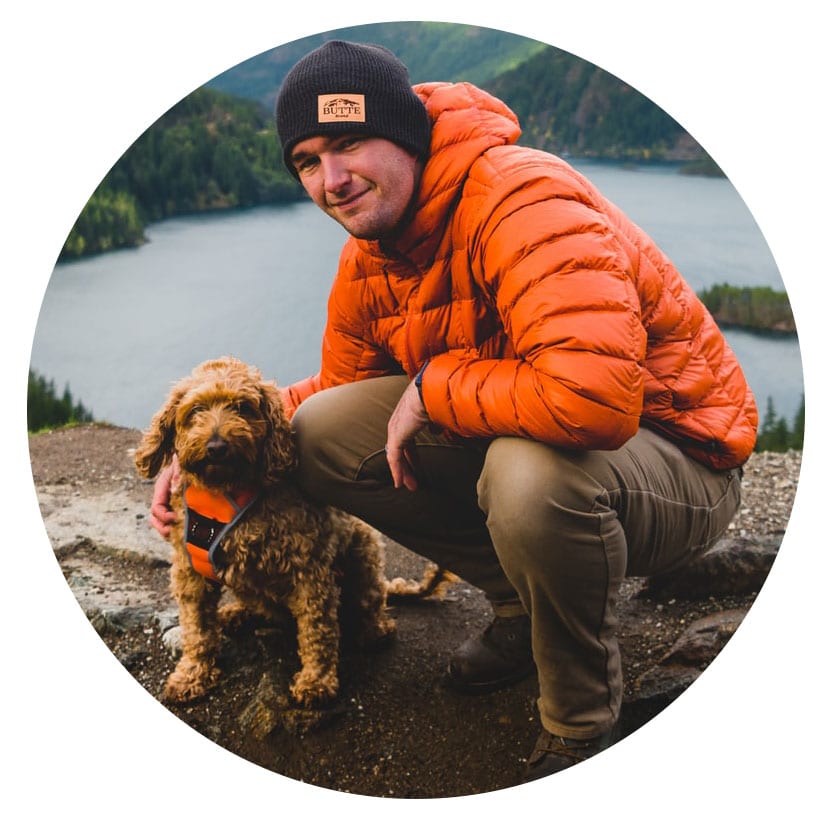 image of a man and dog in outdoor wear near a lake